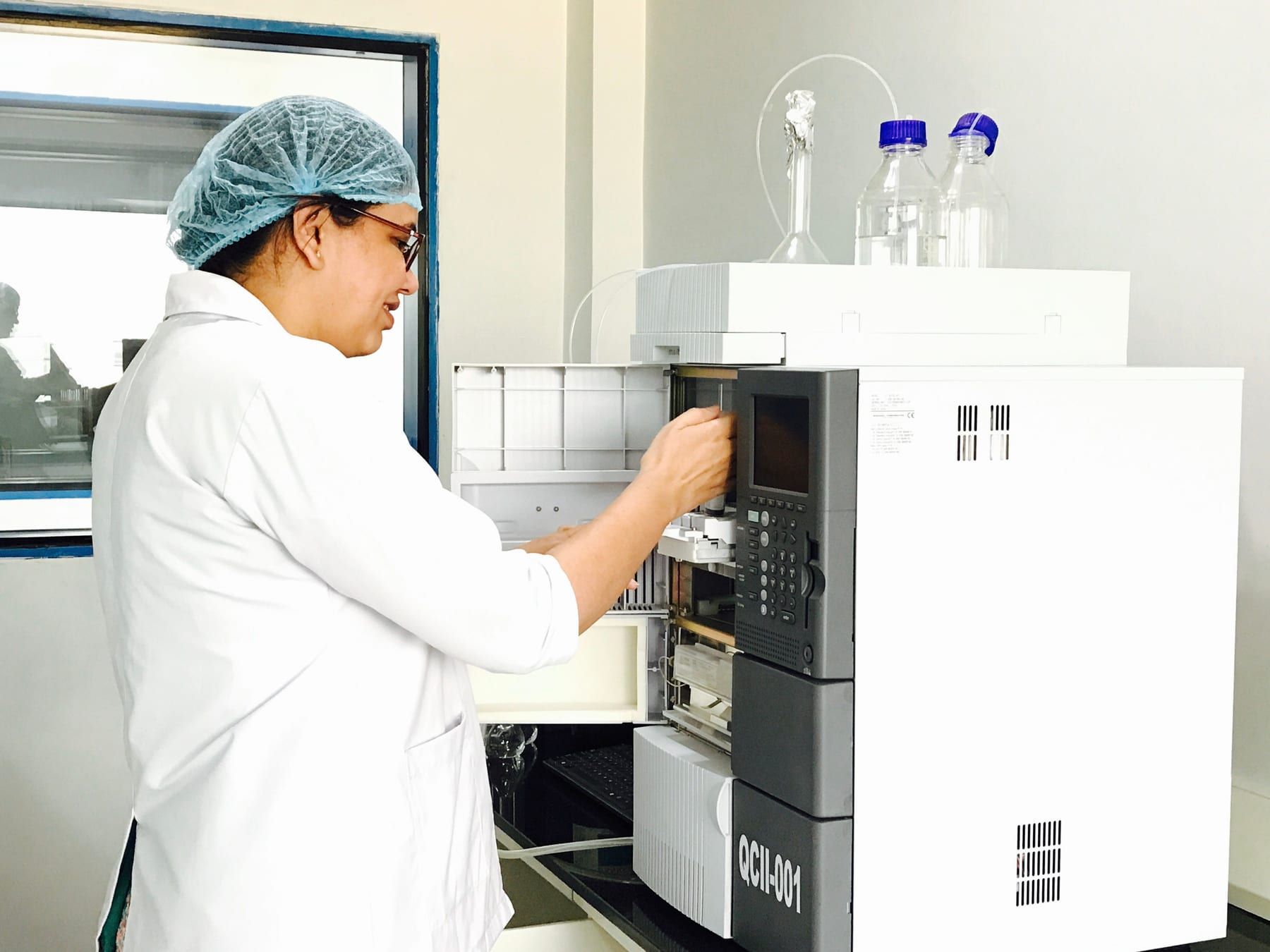 A technician works at a stacked HPLC system in a testing laboratory.