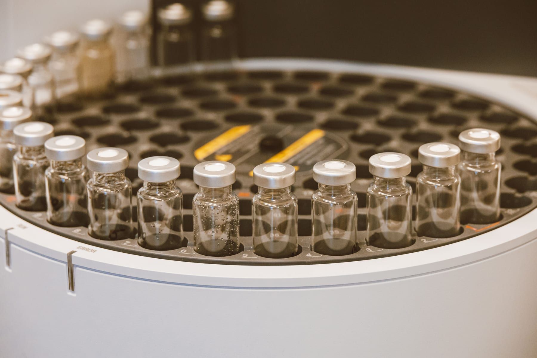 Capped sample vials in the carousel of an autosampler.